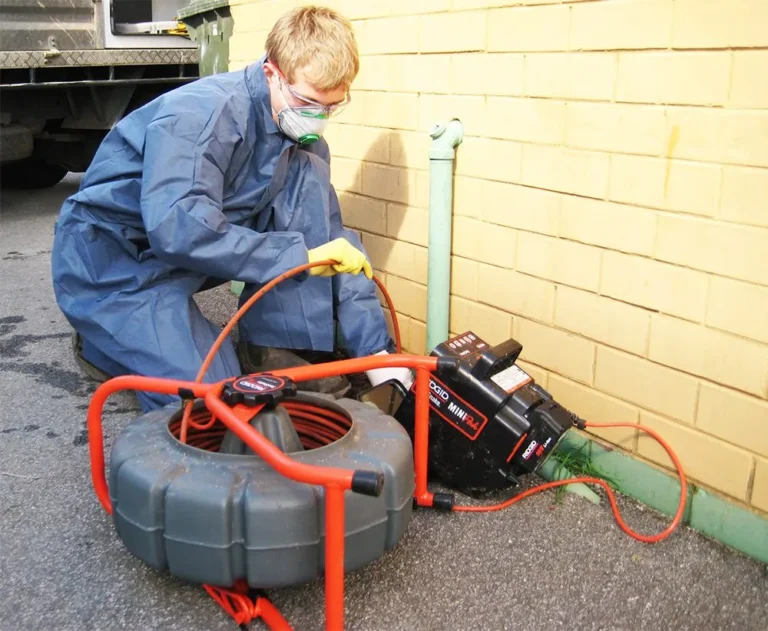 Kalamunda Plumbing technician clearing a blocked drain with a drain machine
