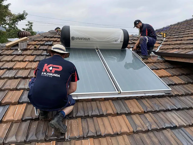 Solar hot water panels being serviced on a roof